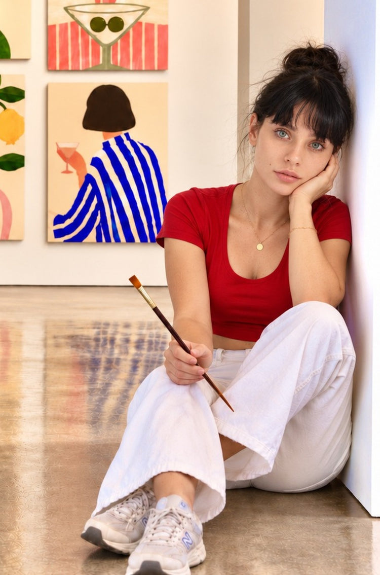 Ayla Heidenberg sitting in front of her prints