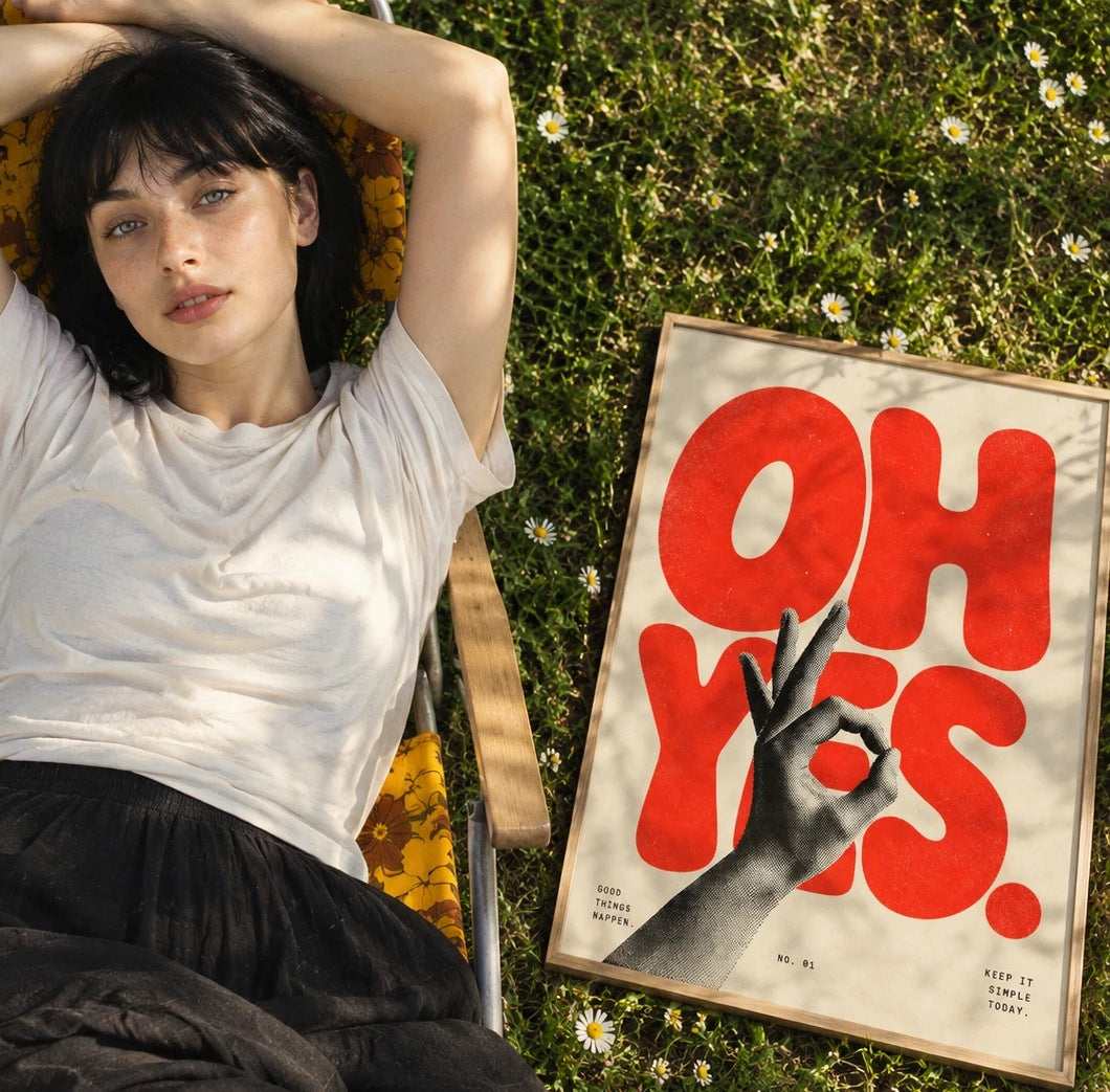 A woman lying in a daisy meadow beside a framed OH YES poster